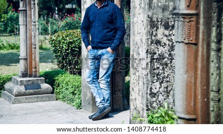Man in a blue jeans standing around a place unique photo