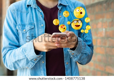 Close-up of man using smartphone sending emojis. Social concept. Royalty-Free Stock Photo #1408775138