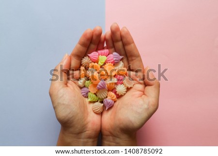 Colorful alua snacks in hand isolated on pastel background