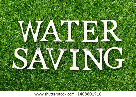 Wood alphabet letter in word water saving on green grass background