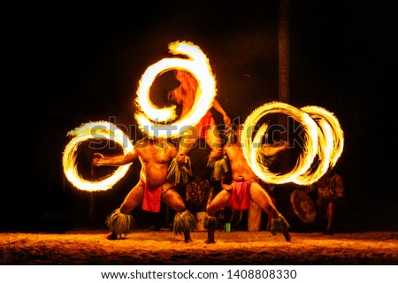 Luau hawaiian fire dancers motion blur tourist attraction in Hawaii or French Polynesia, traditional polynesian dance with men dancer. Royalty-Free Stock Photo #1408808330