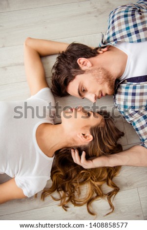 Vertical top above high angle view photo pair beautiful he him his macho she her lady just married honeymoon look gentle eyes overjoyed lying close faces in love apartments flat bright room indoors