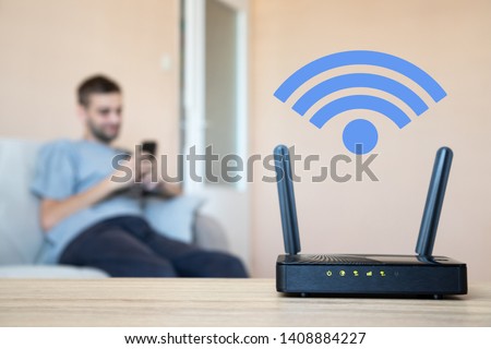 Wifi modem. Young man surfs the internet. Version 2 - wifi symbol. Royalty-Free Stock Photo #1408884227