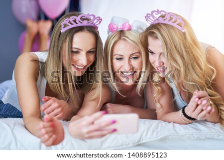 Picture presenting happy group of friends using smartphone
