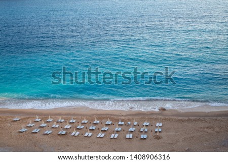 Paradise beach at Turkey. Nobody on the empty beach. Empty beach with closed umbrellas on Kaputaj Kemer Antalya Turkey beach. Holiday icons