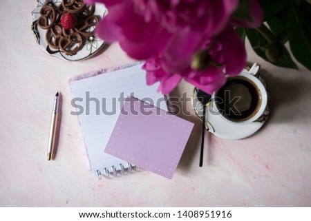 A cup of coffee, empty paper and peony. Background with place for text.