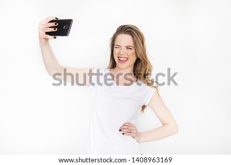 Girl on white with smartphone holding cell phone smiling taking selfie using  internet social media concept 