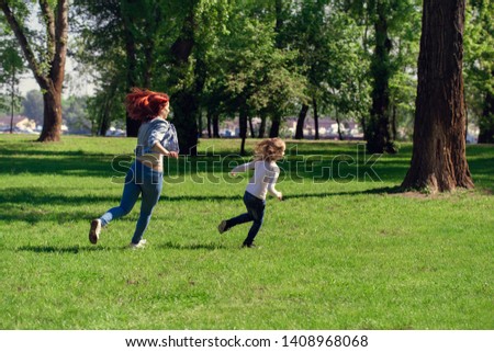 family, parenthood, people concept - happy mother, and little girl running and playing catch game in summer park
