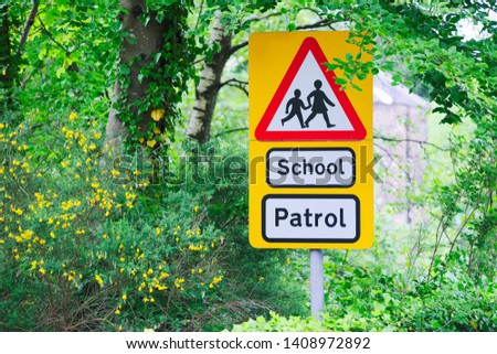 School patrol yellow and red triangle sign near entrance