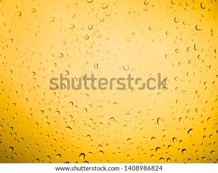 Water Drop On Yellow Background. Rain droplets on glass