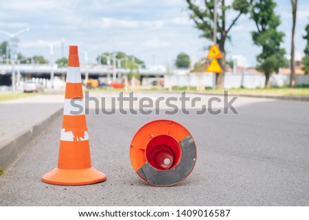Close up of orange road cone on asphalt. Sunset