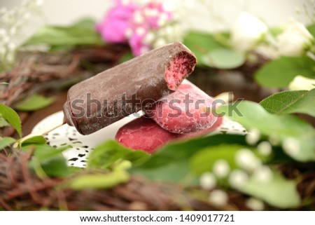 fruit ice cream on a stick, on a background of green leaves