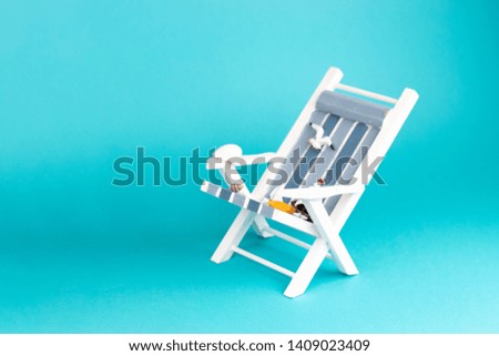 Sun lounger isolated on blue background. Tropical vacation background. Sun lounger on the sandy island, copy space, front view