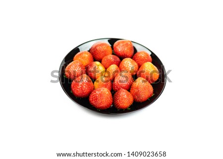 Fresh strawberry fruit in black plate isolated on white background.