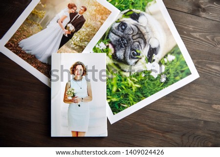 Photo canvas prints. Sample of stretched photography of woman with gallery wrap. Printed photos of a dog and a wedding couple lying on a wooden  table. Top view