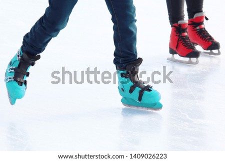 feet of different people skating on the ice rink. Hobbies and recreation. Sports and holidays

