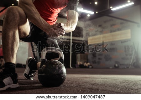Sports background. Young athlete getting ready for crossfit training. Powerlifter hand in talc preparing to bench press.