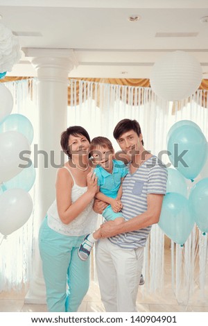 happy family in turquoise costumes against the backdrop of balloons
