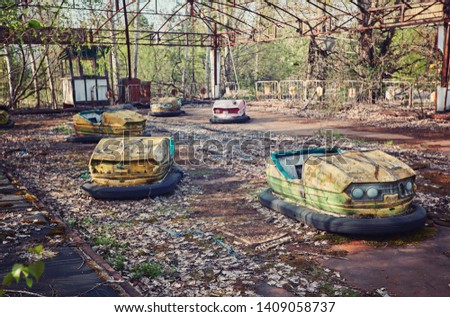 abandoned bumper cars in ruined amusement park in Pripyat city, Exclusion zone of Chernobyl, Ukraine, Eastern Europe Royalty-Free Stock Photo #1409058737