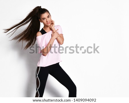 Athletic body brunette with ponytail fitness woman in fashion black and white sportswear on white background