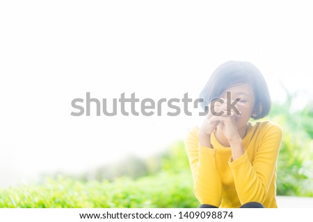 Teenager girl praying in the morning in the park.Little asian girl hand praying,Hands folded in prayer concept for faith,spirituality and religion.