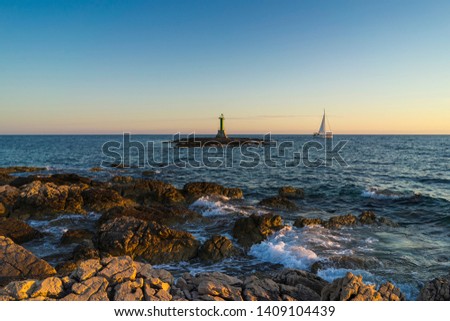 Beautiful nature and landscape photo of coast and lighthouse at Adriatic Sea in Croatia.  Nice outdoors image at sunset. Calm, peaceful spring evening.