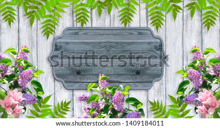 Magnolia flowers and lilac with wooden signboard  and place for your photo or text. Floral garland. Copy space.
