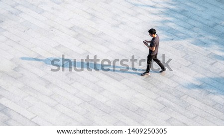 top aerial view people walk on across pedestrian concrete with black silhouette shadow on ground, concept of social still life.