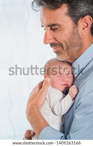 New father sleeping his cute adorable newborn on his lap. Baby expresses calm and peace. Social and Gender equality. Family, new life, childhood, beginning concept.