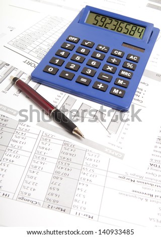 Pen and calculator on paper table with finance report
