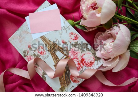 greeting card design. casket with the image of the Eiffel Tower, an envelope on a pink background and pink peonies. invitation. congratulation