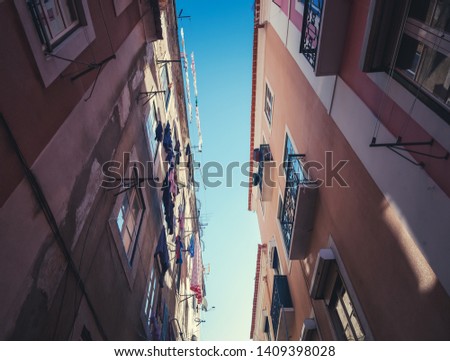 A narrow European street and sky, picture taken from below. Urban background and texture, medieval architecture