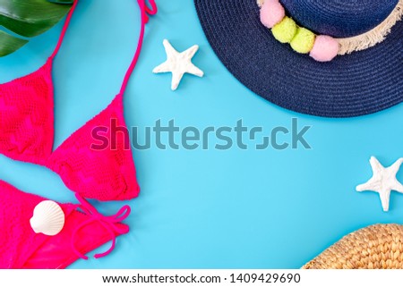 summer blue pink bikini banner with navy blue hat ,pink bikini,sunglasses and seashell on blue background top view.
