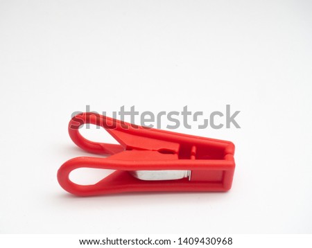 Red plastic clothes pin on white background