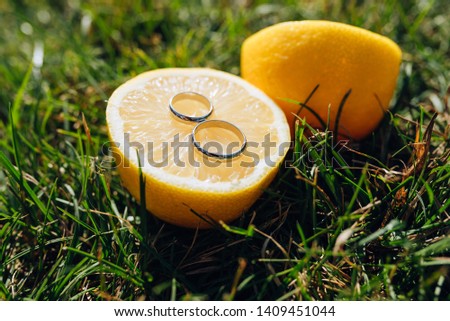 wedding rings on lemon at grass