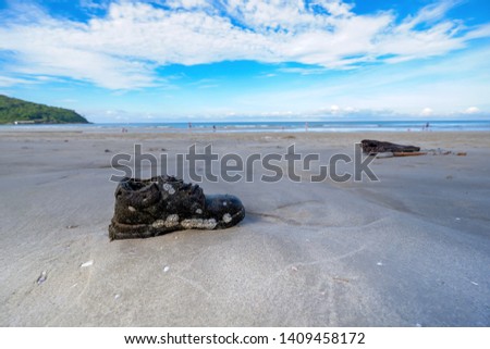 The waves brought an old shoe that sank into the sea for a long time. Returning to the garbage on the beach, humans are the main cause of environmental pollution.