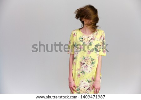 Life is a success. I am pleased with myself. Concept photo of a happy smiling woman satisfied life contented brunette girl in a yellow dress on a gray background with flowing hair. Taken In studio.