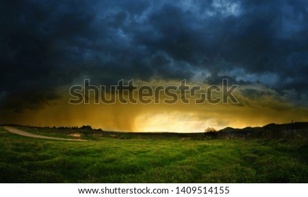 Very intense storm scene with rain on the left side and sunlight