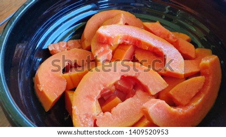 Macro Sliced Red Papaya in Black Bowl