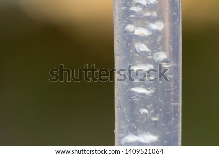Air bubbles are blurred due to movement in a flexible transparent hose.