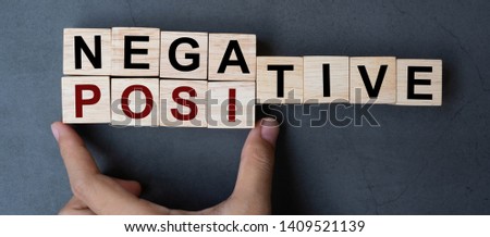 Business man hand holding wooden cube with flip block Negative to Positive word on table background. solution, business and Positive thinking concepts