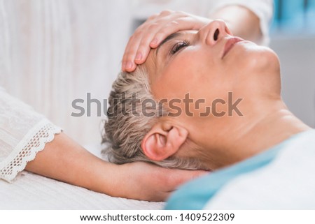 Marma therapy.  Beautiful senior woman lying on massage table and enjoying Ayurveda Facial treatment. 