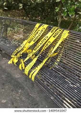 Park Bench with Caution Tape Over Dangerous Section of Bench