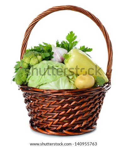 Various vegetables in a brown basket isolated on white background