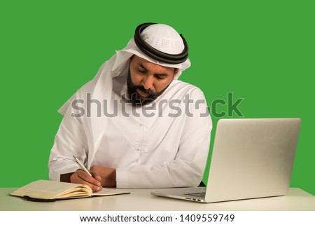 Emirati man working on a laptop.