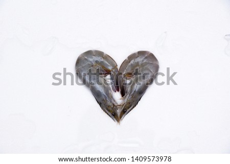 Two fresh shrimp in the shape of a heart on a white background.