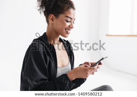 Image of a beautful young amazing sports fitness african woman using mobile phone.