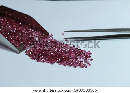Shiny Pink sapphires with and stainless steel Stone Shovel for Loose Stones. Top view on white background. Gemstone background.