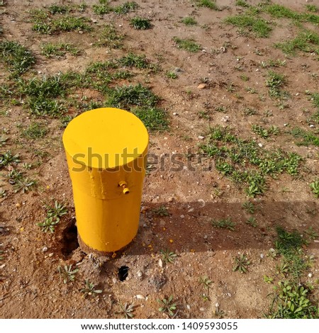 A yellow borehole pipe cap. Underground water supplies concept image. 