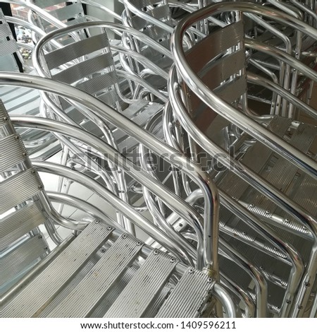 Stacks of silver steel chairs. Seating concept image. 